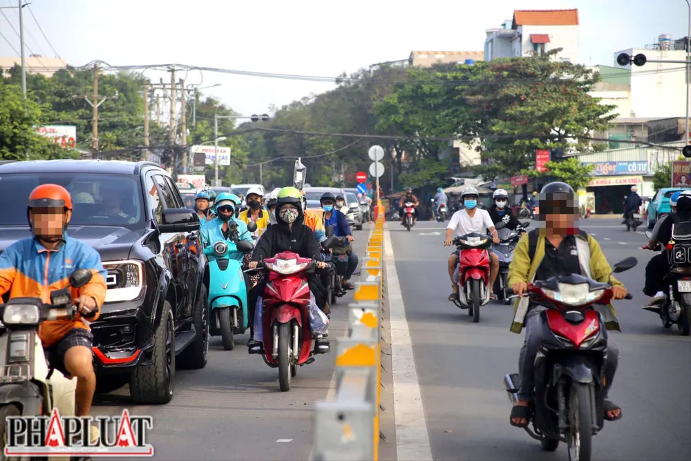 Hàng loạt xe máy nối đuôi nhau chạy ngược chiều trên đường Đặng Thùy Trâm hướng ra Phạm Văn Đồng, bất chấp nguy hiểm và biển báo cấm. Ảnh: PHẠM HẢI z7327729357466_98645e7b483d2df499c1f3d8ce8d1bb0.jpg