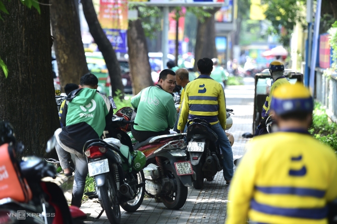 Tài xế xe công nghệ chờ khách trên đường tại trung tâm TP HCM, ngày 24/5. Ảnh: Thanh Tùng