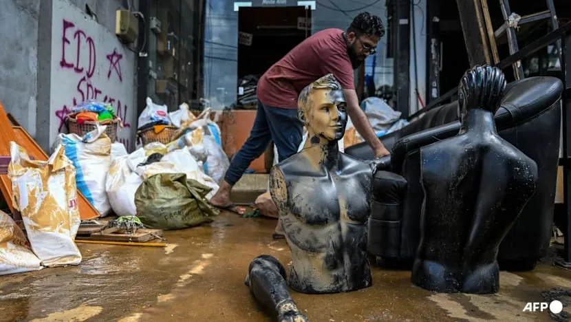 Một người đàn ông dọn bùn trong cửa hàng quần áo sau lũ quét do bão Ditwah tại thị trấn Gampola, quận Kandy, ngày 4-12. Ảnh: Ishara S Kodikara/AFP Sri Lanka, bão, lũ