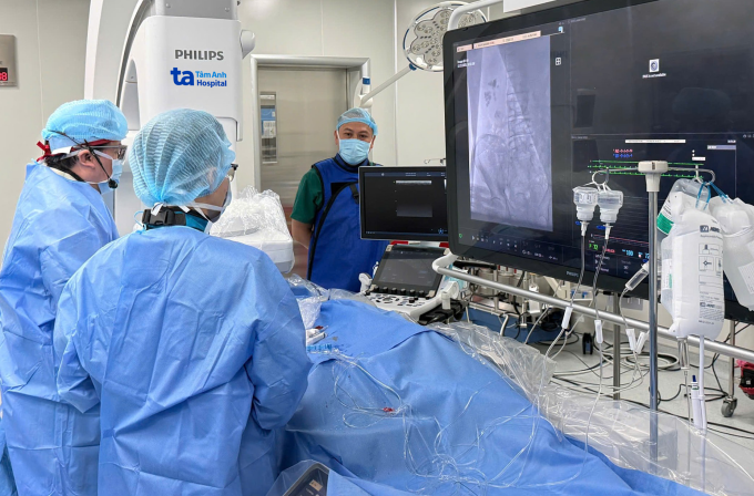 GS Nhân (ngoài cùng bên trái) cùng ê kíp cấy van động mạch chủ qua ống thông cho bệnh nhân. Ảnh: Trung Vũ