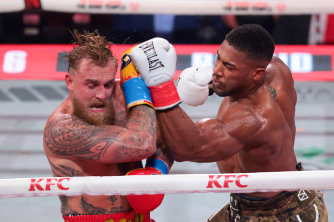 Anthony Joshua (phải) ra đòn trong trận gặp Jake Paul tại Miami, Mỹ, ngày 20/12/2025. Ảnh: Reuters