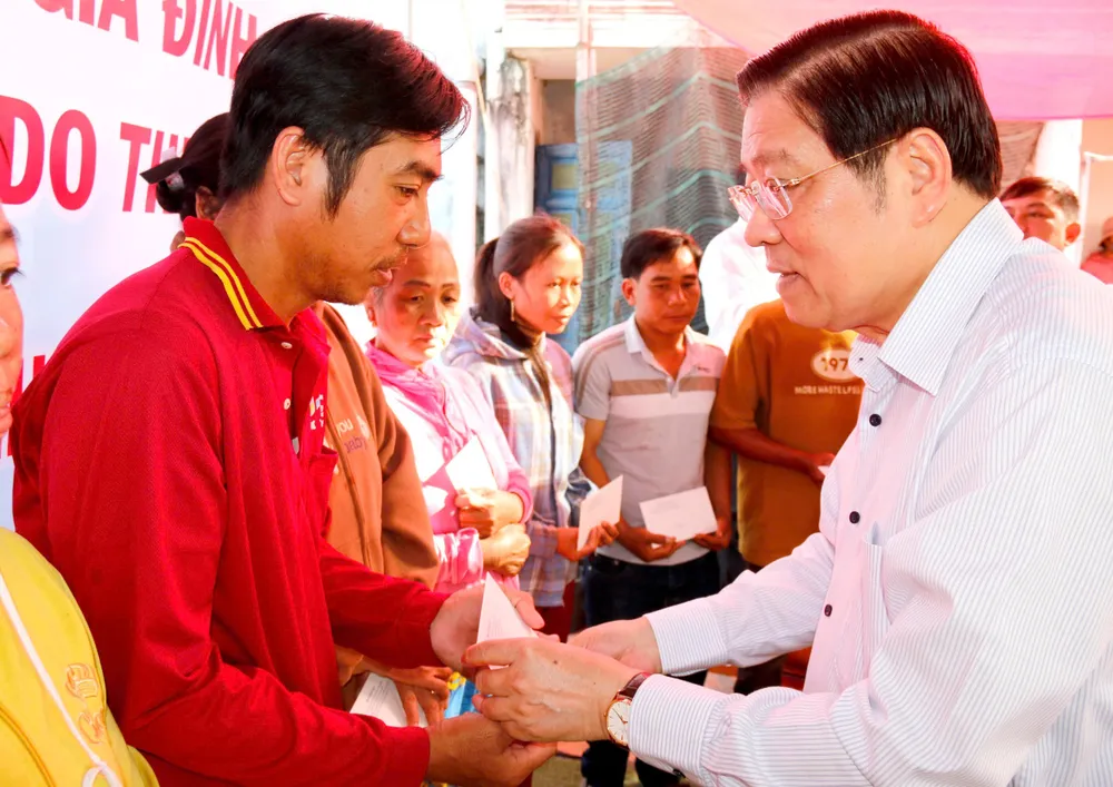 Ông Phan Đình Trạc trao quà cho các hộ dân bị thiệt hại do lũ lụt. trưởng Ban Nội chính Trung ương