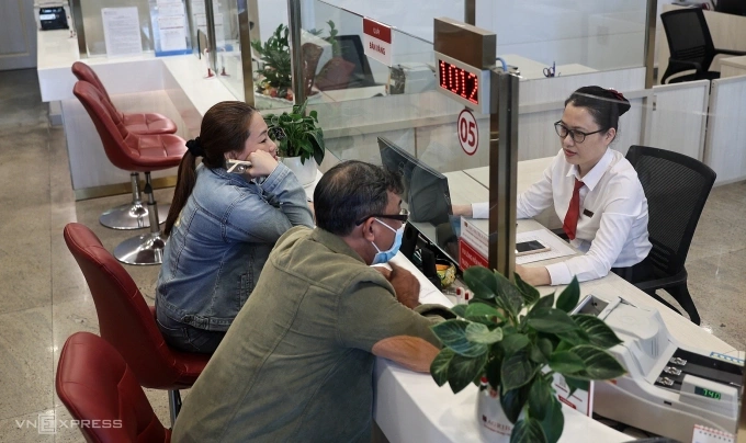 Người dân dang giao dịch tại quầy của một ngân hàng tại TP HCM. Ảnh: Quỳnh Trần