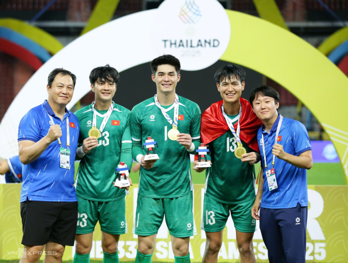 HLV thủ môn Lee Woon-jae, thủ môn Cao Văn Bình, Trần Trung Kiên và Nguyễn Tân (từ trái sang) tại lễ trao huy chương bóng đá nam SEA Games 33 trên sân Rajamangala ở Bangkok, Thái Lan ngày 18/12/2025. Ảnh: Đức Đồng