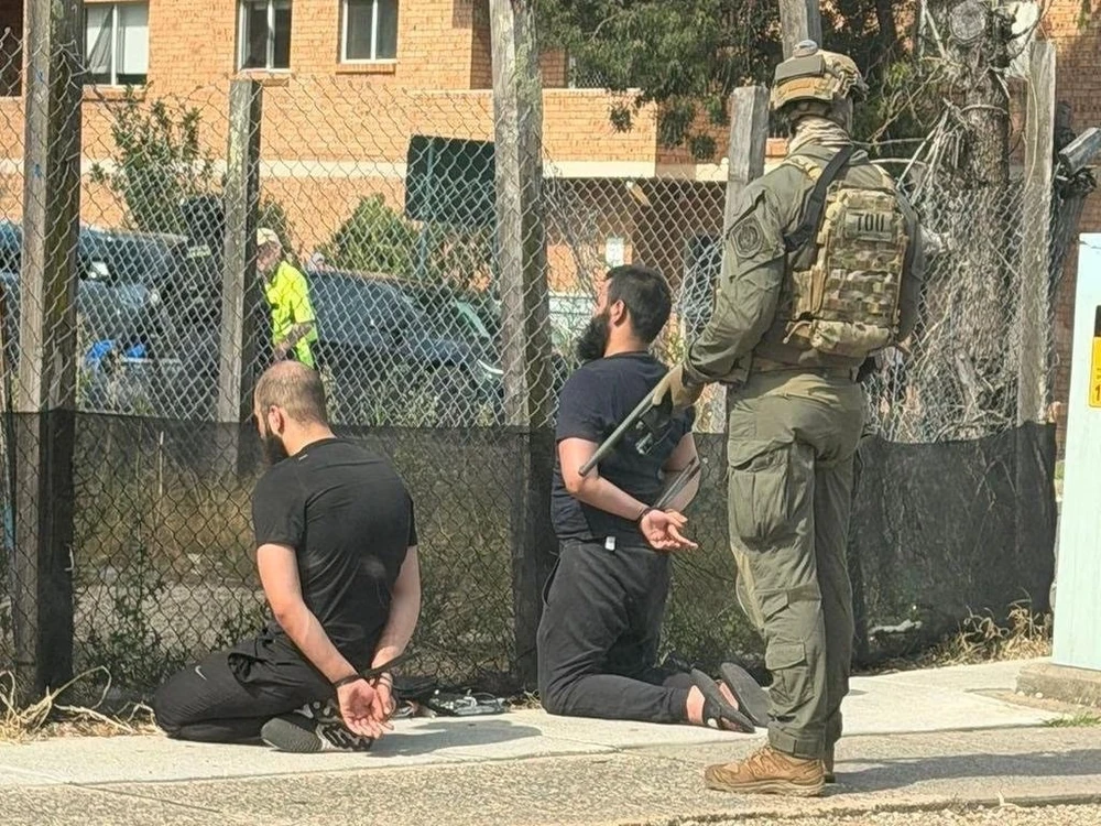 Cảnh sát hôm 18-12 khống chế 2 đối tượng bị tình nghi lên kế hoạch "tấn công bạo lực" ở tây nam TP Sydney (Úc), 5 người khác liên quan cũng bị bắt giữ. Ảnh: 9NEWS 1912 Úc bắt 7 người nghi chuẩn bị tấn công bạo lực ngay hiện trường xả súng ở Sydney.jpg