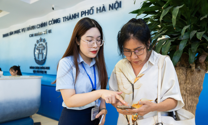 Nhân viên hỗ trợ người dân tại Trung tâm phục vụ hành chính công Hà Nội. Ảnh: Tùng Đinh