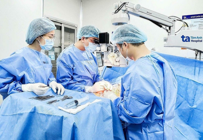 Bác sĩ Vinh (giữa) cùng êkíp vi phẫu tìm tinh trùng cho người bệnh. Ảnh: Hoài Thương