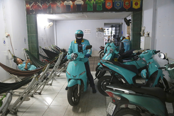 Tài xế nghỉ ngơi chở sạc pin xe máy điện tại quán cà phê có lắp trụ sạc tập trung trên đường số 4, phường Hạnh Thông, ngày 25/12. Ảnh: Đình Văn