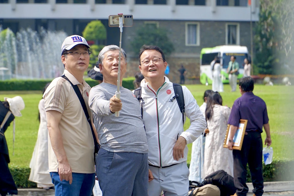 Du khách nước ngoài thích thú chụp ảnh tại Dinh Độc Lập. Ảnh: HẢI NHI ngày đầu năm (3).jpg