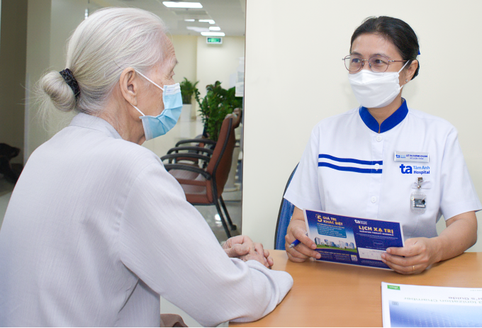 Điều dưỡng khoa Xạ trị dặn dò lịch xạ trị tiếp theo cho bà Tình. Ảnh: Bệnh viện Đa khoa Tâm Anh