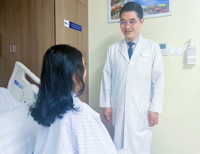 Bác sĩ Dũng hỏi thăm sức khỏe bệnh nhân sau phẫu thuật. Ảnh: Hạ Vũ