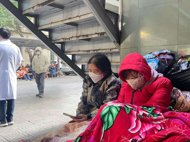 Nhiều người ngồi ngay dưới gầm cầu thang để chợp mắt một chút cho đỡ mỏi. Ảnh: N.T