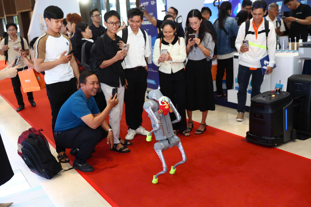 Khách tham quan thích thú khi tương tác với chó robot Unitree. Ảnh:Tùng Quỳnh