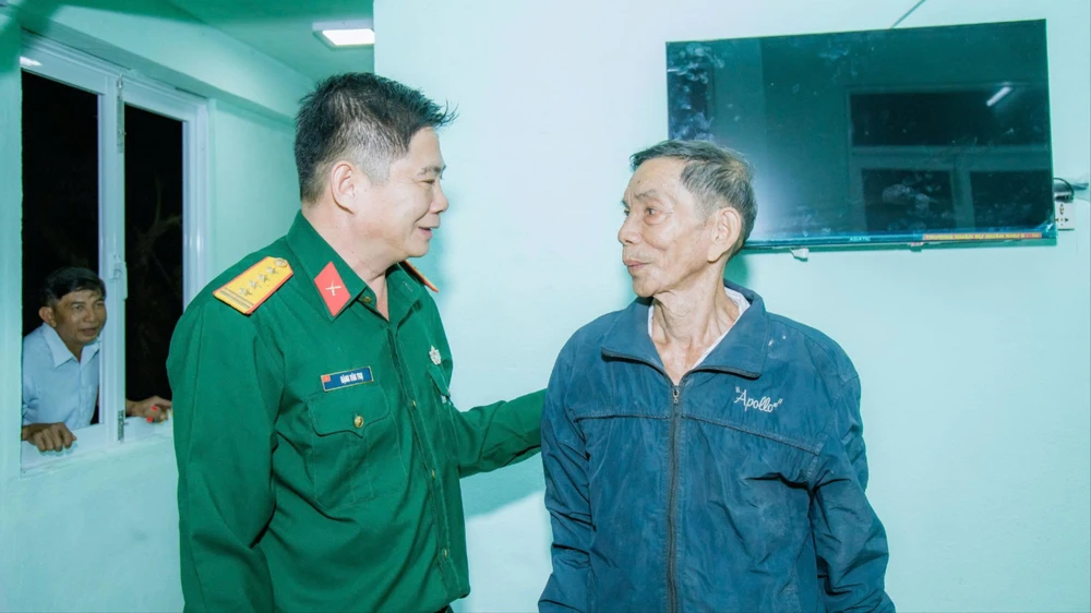 Cụ Phương (bìa trái) vui mừng khi được bàn giao nhà mới. Ảnh: N.N bộ đội 1.jpg