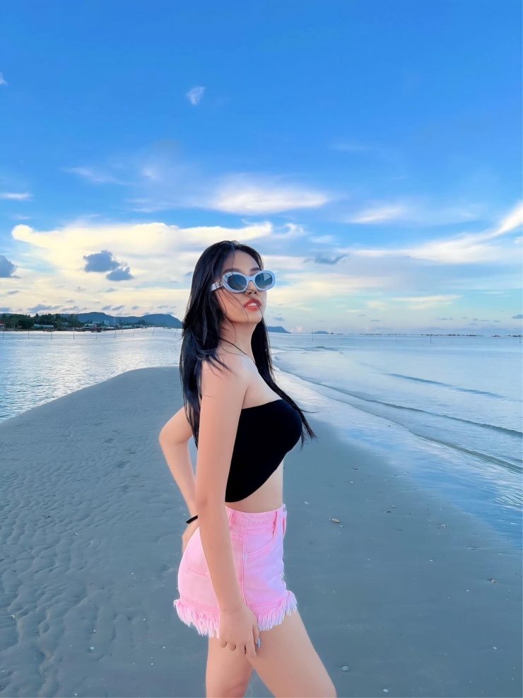 Trang phục dạo biển với bra top khoe eo thon cùng quần shorts. Để thêm thời trang, cô sử dụng kính mắt retro kiểu thập niên 1930.