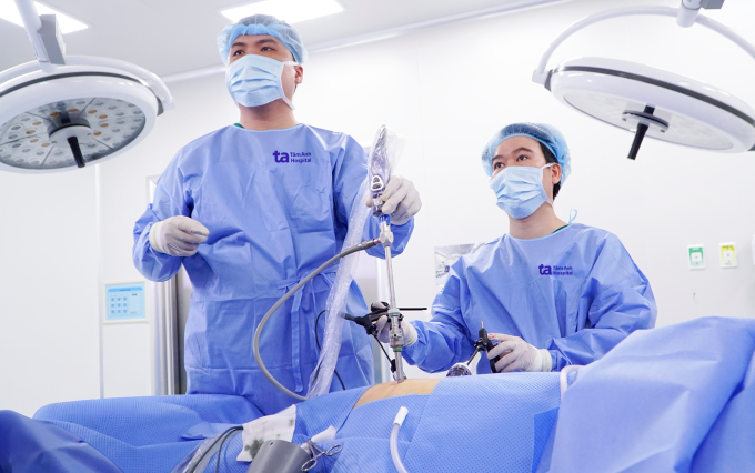 Bác sĩ Trúc (phải) và bác sĩ Đoàn Ngọc Thiện phẫu thuật nội soi lấy sỏi cho bà Hoàng. Ảnh: Bệnh viện Đa khoa Tâm Anh