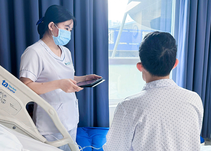 Điều dưỡng đang hướng dẫn chăm sóc sau phẫu thuật cho anh Hoàng. Ảnh: Bệnh viện Đa khoa Tâm Anh