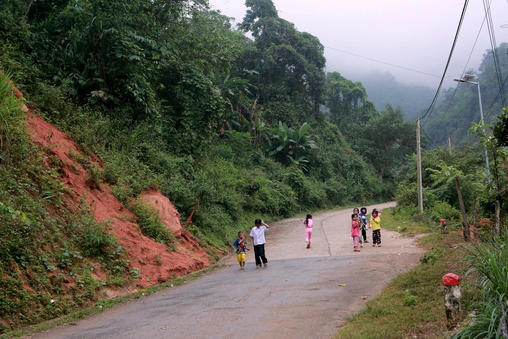 Những đứa trẻ nô đùa dưới chân núi nơi mỗi lần mưa lũ là người dân phải tháo chạy tìm nơi an toàn. Ảnh: ĐẶNG TRUNG 1U1B8027.JPG