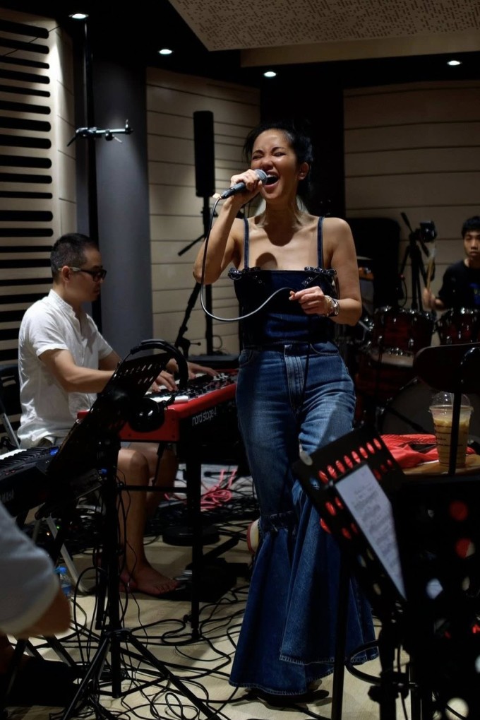 Nữ ca sĩ phối quần jean ống loe và áo hai dây cùng chất liệu trong một buổi tập nhạc hồi cuối năm.