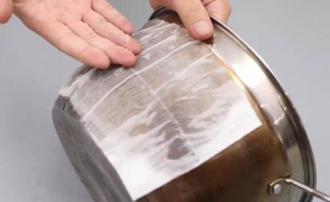 Dùng khăn giấy thấm dung dịch gồm giấm và kem đánh răng ủ lên bề mặt nồi, chảo giúp làm sạch dễ dàng hơn.