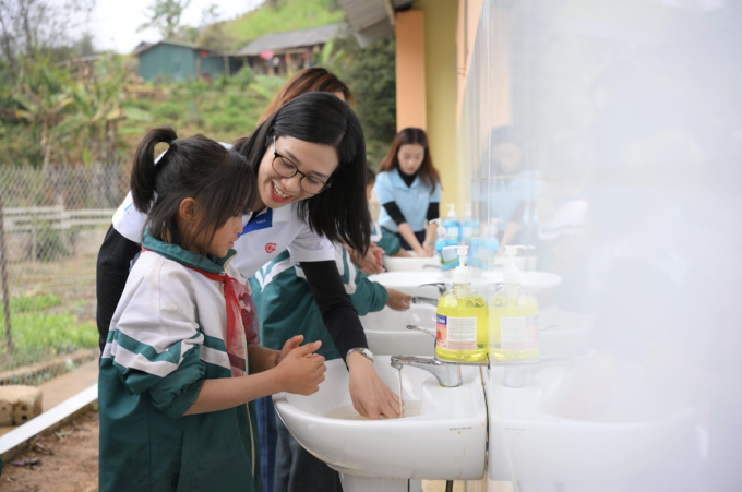 Đại diện Bảo hiểm GIC cùng rửa tay với học sinh ở nhà vệ sinh mới. Ảnh: Home Credit Việt Nam