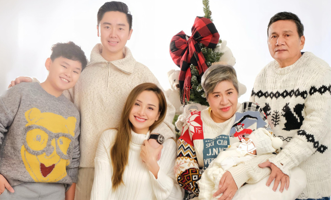 Hoa hậu Diễm Hương (ngồi thứ ba từ trái sang) bên chồng (thứ hai từ trái sang), bố mẹ và hai con. Ảnh: Nhân vật cung cấp