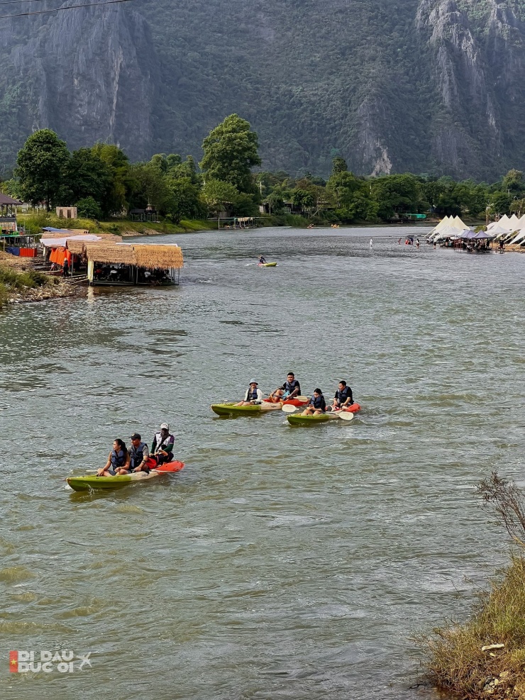 Du khách chèo thuyền trên sông ở Vang Vieng