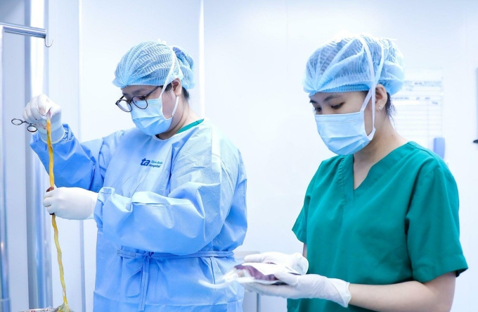Nhân viên Ngân hàng Mô, Bệnh viện Đa khoa Tâm Anh TP HCM thu thập máu và mô dây rốn cho con trai anh Thanh. Ảnh: Tuệ Diễm