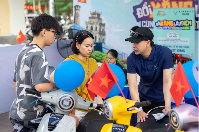 Nhân viên đại lý VinFast (phải) tư vấn người dùng chọn mua xe máy điện. Ảnh: Tuấn Vũ