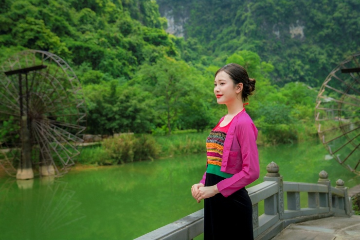 Thiếu nữ mang trang phục dân tộc Mường bên guồng nước