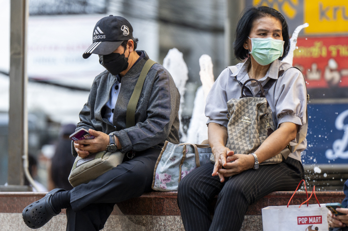 Người dân ngồi bên một đài phun nước ở thủ đô Bangkok, Thái Lan hôm 16/1. Ảnh: AFP