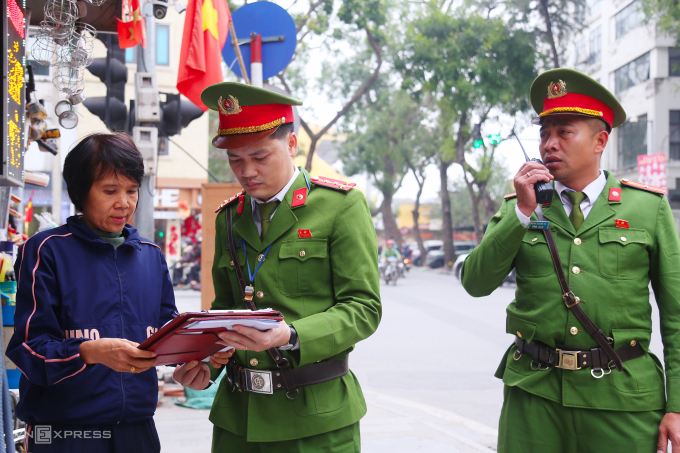 Công an yêu cầu hộ kinh doanh trên phố An Trạch ký cam kết không vi phạm trật tự đô thị, vệ sinh môi trường, chiều 27/1. Ảnh: Phạm Dự
