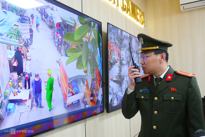 Trung tá Vũ Minh, Phó trưởng Công an phường Ô Chợ Dừa chỉ đạo xử lý vi phạm từ trung tâm chỉ huy. Ảnh: Phạm Dự