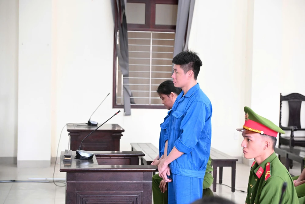 Hai bị cáo Thắng (người gần công an) và Việt tại phiên tòa xét xử. Ảnh: HUỲNH DU