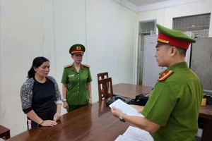 Công an đọc lệnh bắt bị can. Ảnh: CA