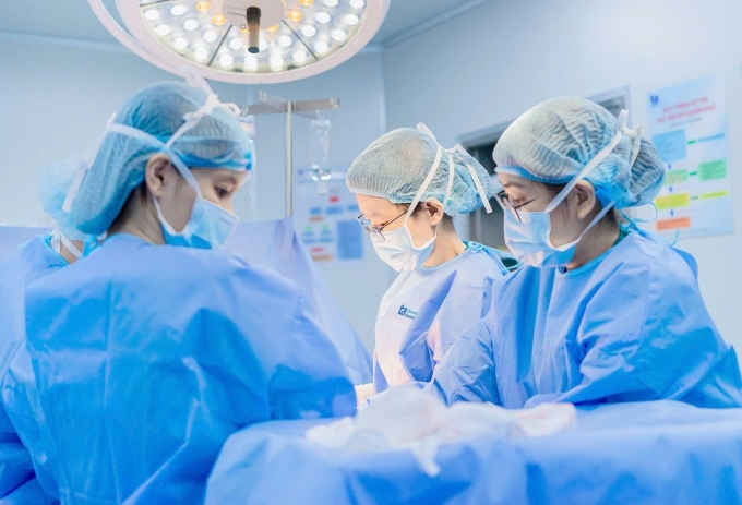 Bác sĩ Lâm Khoa (giữa) mổ lấy thai cho chị Nghi. Ảnh: Tuệ Diễm.