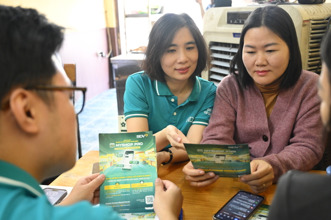 Nhân viên BIDV hỗ trợ các hộ kinh doanh sử dụng MyShop Pro. Ảnh: BIDV