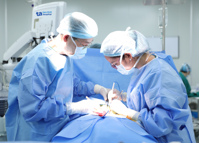 Bác sĩ Hằng (phải) và ê kíp phẫu thuật cắt bướu cường giáp cho bệnh nhân. Ảnh: Trung Vũ