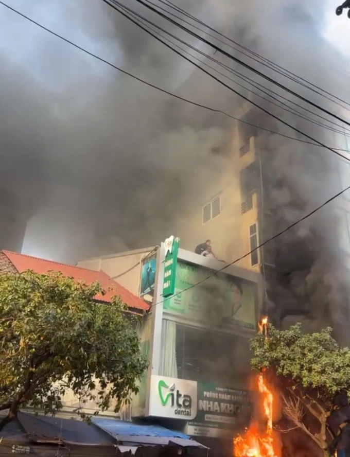 Khói lửa bao trùm tòa nhà 6 tầng và cháy lan sang bên cạnh. Ảnh: Phạm Chiểu.