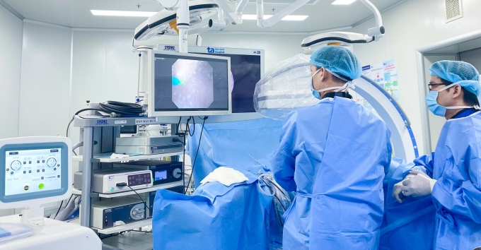 Bác sĩ Cương (trái) và BS.CKI Phan Trường Nam phẫu thuật nội soi tán sỏi ngược dòng cho anh Huy. Ảnh: Bệnh viện Đa khoa Tâm Anh