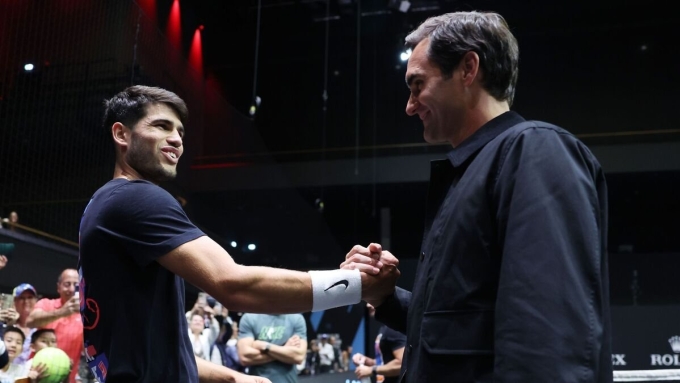 Federer bắt tay Alcaraz trong một dịp dự khán trận đấu của tay vợt hậu bối người Tây Ban Nha. Ảnh: AFP