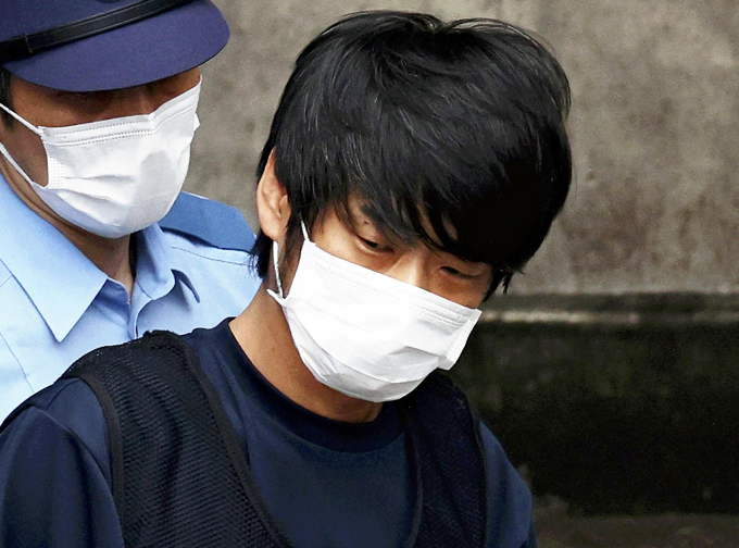 Tetsuya Yamagami (áo đen) bị áp giải ra tòa án ở thành phố Nara, tỉnh Nara tháng 7/2022. Ảnh: AFP