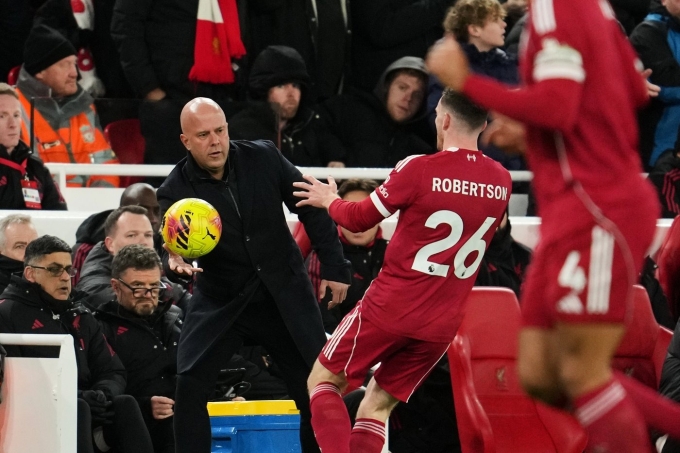 HLV Slot (đen) khẩn trương đưa bóng cho Robertson, ở trận gặp Leeds, trên sân Anfield, Liverpool hôm 1/1. Ảnh: Reuters 