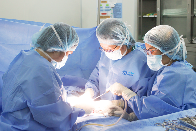 Bác sĩ Thu (giữa) phẫu thuật cắt tử cung và hai vòi trứng cho bà Thuận. Ảnh: Tuệ Diễm