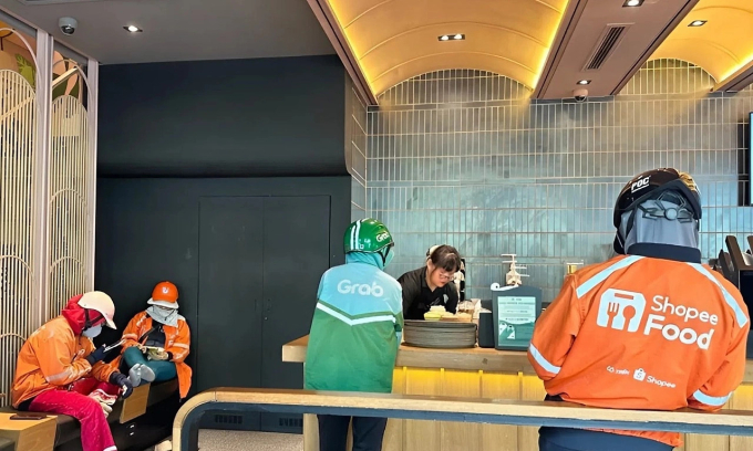 Tài xế chờ nhận đồ uống đi giao tại một quán cà phê trên đường Nguyễn Thị Minh Khai, TP HCM, tháng 3/2025. Ảnh:Dỹ Tùng