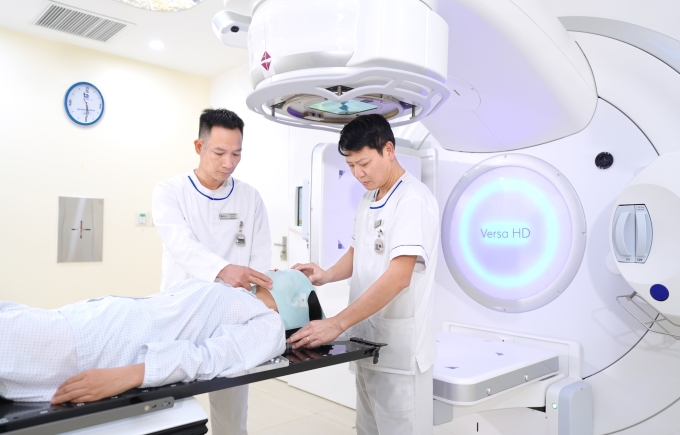 Kỹ thuật viên tháo mặt nạ cố định cho người bệnh ngay sau xạ trị ngoài. Ảnh: Bệnh viện Đa khoa Tâm Anh