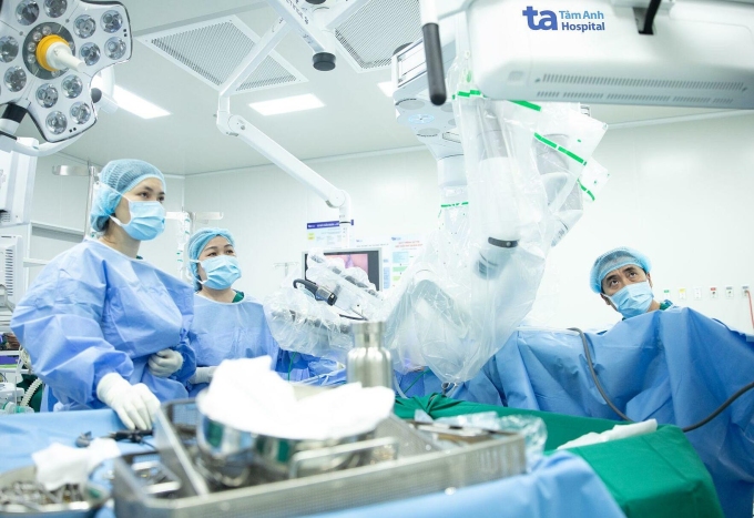 Bác sĩ Thanh Tâm (giữa) và ê kíp phẫu thuật sa tử cung bằng robot cho chị Hằng. Ảnh: Trung Vũ