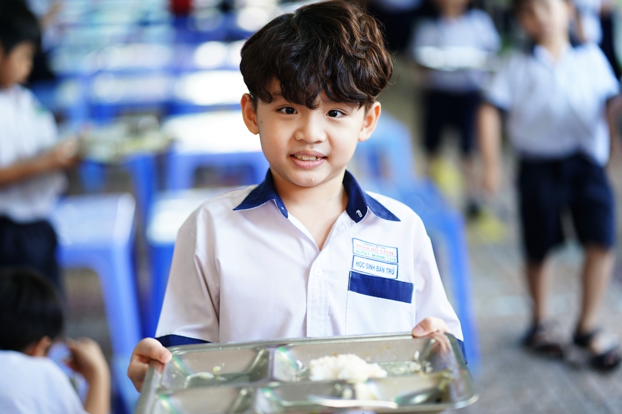 Cảnh tượng lạ tại cổng trường tiểu học ở TP.HCM mỗi buổi trưa: Phụ huynh tay xách cơm, người chờ đón con về nhà- Ảnh 6.