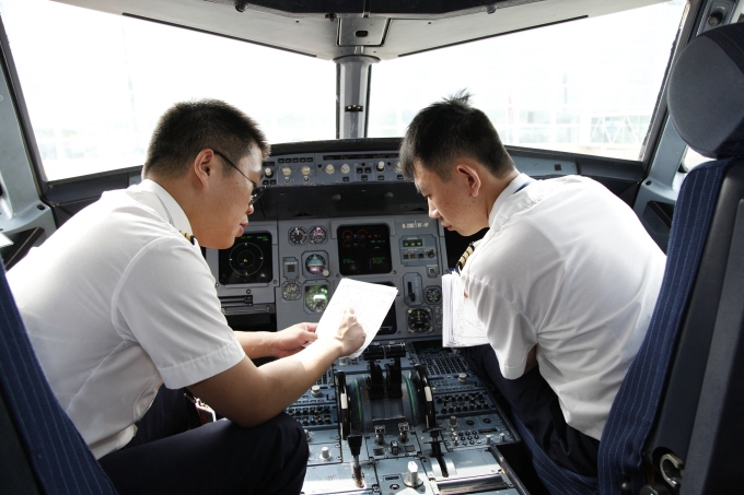 Phi công trao đổi trong buồng lái một phi cơ tại sân bay thành phố Vô Tích, tỉnh Giang Tô, Trung Quốc tháng 7/2014. Ảnh: AFP