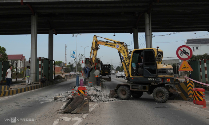Xe cơ giới tiến hành tháo dỡ các dải bêtông ở làn thu phí. Ảnh: Trường Hà
